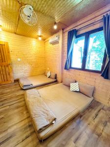 a bedroom with two beds in a wooden room at Tà Đùng May Farm in Biđong