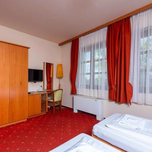a hotel room with two beds and a desk at Gastland M0 Hotel & Conference Center in Szigetszentmiklós