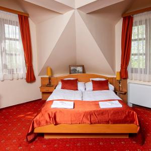 ein Schlafzimmer mit einem großen Bett und einem roten Teppich in der Unterkunft Gastland M0 Hotel & Conference Center in Szigetszentmiklós