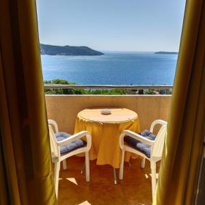 a table and chairs on a balcony with a view of the ocean at Apartments "Belle Vue" in Herceg-Novi
