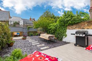 Un patio con una mesa y una estufa en un patio trasero. en Oyster Shore By Bloom Stays, en Whitstable