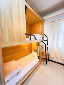 a small room with bunk beds in it at Waveflo Hostel 浪花青旅 in Hong Kong