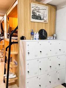 a bedroom with a chest of drawers and a bunk bed at Waveflo Hostel 浪花青旅 in Hong Kong
