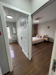 a bedroom with a bed and a mirror at OYO Welsh Holiday Accommodation - Modern Stay in Pembroke Dock +30 photos