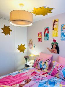 1 dormitorio con 1 cama con sábanas y fotografías coloridas en THE ENCHANTED HOUSE ( 15 min walk to Disney), en Serris