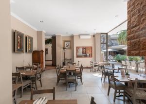 um restaurante vazio com mesas e cadeiras de madeira em Villa Africa Boutique Hotel & Spa em Pretoria