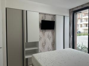 een slaapkamer met een bed en een tv aan de muur bij Сарафово Лукс Тераса Първа Линия in Sarafovo