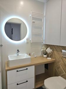 une salle de bain avec un lavabo et un miroir dans l'établissement Apartament 10B Niebieskie Apartamenty z basenem krytym, odkrytym, salą zabaw, animacjami, à Poddąbie