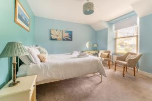 niebieska sypialnia z łóżkiem, stołem i krzesłami w obiekcie Daisy Cottage w mieście Windermere