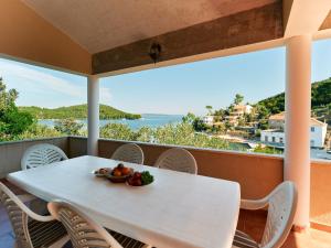 un tavolo bianco con un cesto di frutta sul balcone di Apartments Eva a Savar