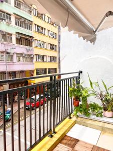 un balcone di un appartamento con vista su una strada di Waveflo Hostel 浪花青旅 a Hong Kong