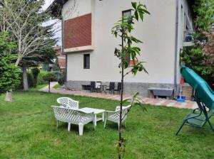 ogród ze stołem, krzesłami i placem zabaw w obiekcie Bus Station Hostel w mieście Peć
