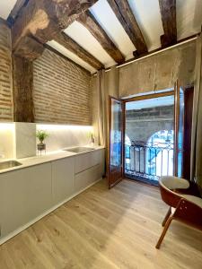 a large kitchen with a large window and a table at Lauramer Plaza Nueva in Bilbao