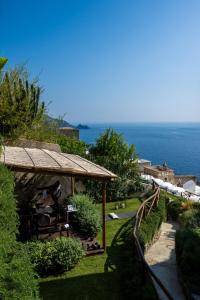 vista di una casa con l'oceano sullo sfondo di AMORE RENTALS - Villa Blu a Praiano