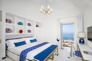 una camera da letto con un letto, una scrivania e una finestra di AMORE RENTALS - Villa Blu a Praiano Altre 84 foto