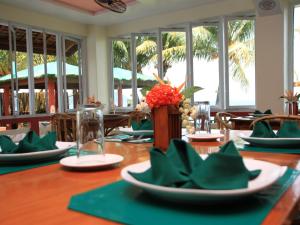 a dining room with a table with green place settings at Badladz Beach and Dive Resort in Puerto Galera