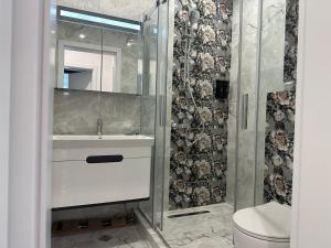 een badkamer met wastafel en douche bij Сарафово Лукс Тераса Първа Линия in Sarafovo +15 foto's