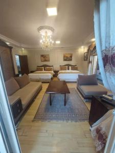- un salon avec deux lits et un canapé dans l'établissement ڤيلا فاخرة لك بجميع الخدمات بالساحل الشمالي, à Qaryat Shākūsh