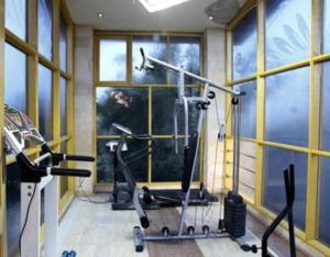 - une salle de sport avec 3 vélos d'exercice dans une pièce dotée de fenêtres dans l'établissement ڤيلا فاخرة لك بجميع الخدمات بالساحل الشمالي, à Qaryat Shākūsh