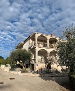a white building with a balcony on top of it at Seafront Apartment Jadri in Umag