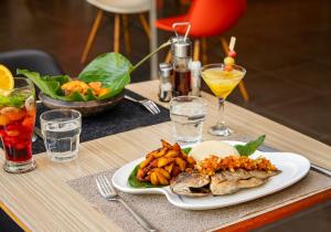 a table with a plate of food and drinks at Ibis Styles Abidjan Plateau in Abidjan