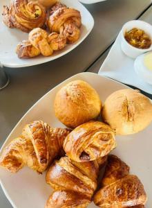 dos platos de bollería y panecillos en una mesa en VILLA - MER - PISCINE - JARDIN, en Foulpointe