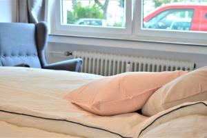 - un lit avec un oreiller et une chaise dans une chambre dans l'établissement Rüttenscheid/ Große Wohnung, à Essen