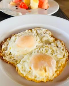 un huevo frito en un plato blanco en una mesa en VILLA - MER - PISCINE - JARDIN, en Foulpointe