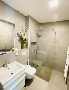 a white bathroom with a sink and a toilet at Brand New Luxury Studio in Belair with balcony in Luxembourg