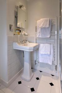 a bathroom with a sink and a mirror and towels at Wellwood Manor in Pitlochry