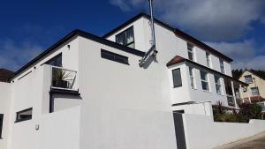 uma casa branca com uma parede branca em Charnwood Guest House em Lyme Regis