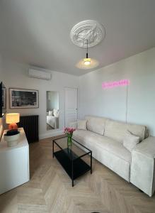 ein Wohnzimmer mit einem weißen Sofa und einem Tisch in der Unterkunft Appartement, bel aperçu Tour Eiffel in Rueil-Malmaison