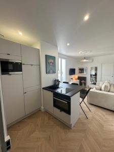 eine Küche mit einer Arbeitsplatte und ein Wohnzimmer in der Unterkunft Appartement, bel aperçu Tour Eiffel in Rueil-Malmaison