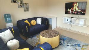 a living room with a couch and a tv at Weli homestay in Naivasha