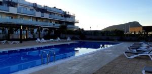 uma piscina com cadeiras e um hotel em Apartment 2 bedrooms and terrace em La Tejita