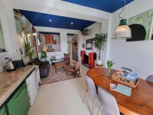 een keuken en een woonkamer met een houten tafel en stoelen bij Studio Blank - Arthouse in Den Oever