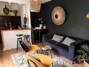 ein Wohnzimmer mit einer blauen Couch und eine Küche in der Unterkunft Ker Amice , une parenthèse de calme près de Bordeaux , 3 chambres avec Spa Privatif in Saint-Loubès