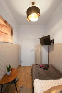Habitación con 2 camas, mesa y luz en ClickTheFlat Wolska Apart Rooms, en Varsovia