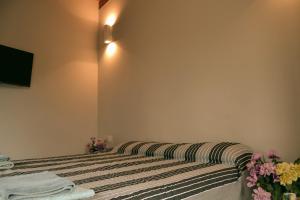 a bedroom with a bed with a striped blanket at B&B SEBA e PAOLA in Sonnino