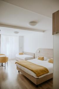 a bedroom with two beds and a table at Hotel Venezia in Trento