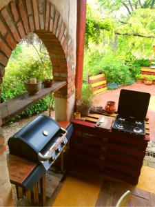 an outdoor kitchen with a grill and a stove at Krasberry Ježev brlog in Komen