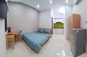 ein Schlafzimmer mit einem Bett und einem Tisch sowie eine Küche in der Unterkunft Duc Hanh Apartment in Đà Nẵng