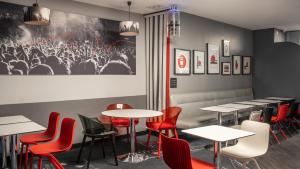 un comedor con mesas y sillas rojas en Hotel Inn Design Paris Place d’Italie (ex Timhotel) en París