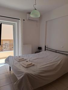 Un dormitorio con una cama blanca con toallas. en Kanelli΄s apartments, en Monemvasia