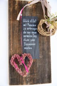un signe en forme de cœur sur une table en bois avec une couronne dans l'établissement Naturidyll am See, à Fußach