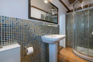 a bathroom with a sink and a glass shower at Hotel La Casa del Califa in Vejer de la Frontera