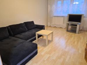 a living room with a black couch and a table at Dauman Apartment in Narva