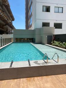 a swimming pool in front of a building at RED DESIGN - Apto completo 2 Qts 901 in Vitória
