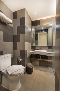 a bathroom with a toilet and a sink at Arte Hotel Bandar Lampung in Bandar Lampung
