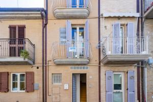 ein Gebäude mit Balkon auf der Seite in der Unterkunft Appartamento Duplex Cairoli - MyHo Casa in Porto San Giorgio